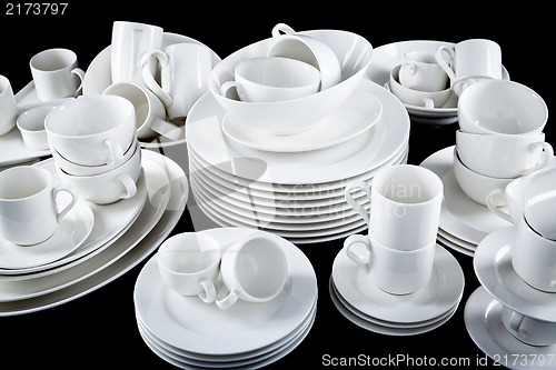 Image of mixed white dishes cups and plates isolated on black