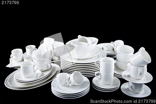 Image of mixed white dishes cups and plates isolated on black