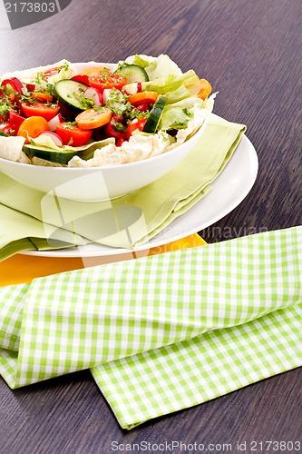 Image of fresh mixed colorful salad on wooden table 