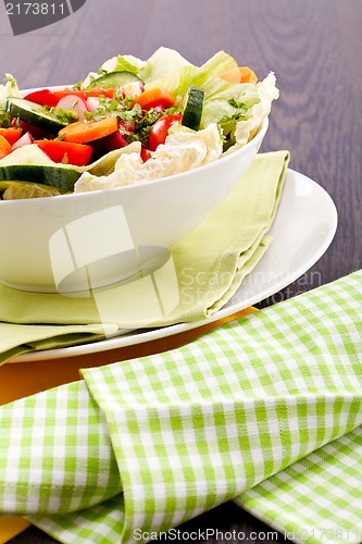 Image of fresh mixed colorful salad on wooden table 