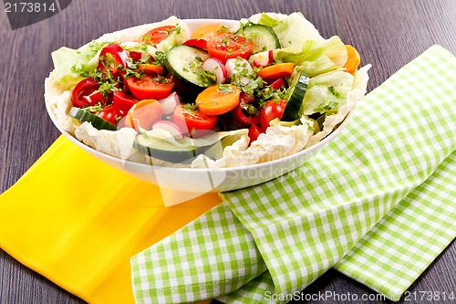 Image of fresh mixed colorful salad on wooden table 