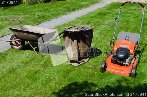 Image of mower and wheelbarrow to throw the grass 