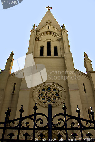 Image of brick facade rose window and blue sky  