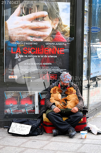 Image of PARIS - May 7: A homeless man sitting on the street with a dog a