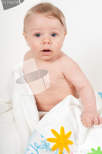 Image of Little boy with flowers on white blanket