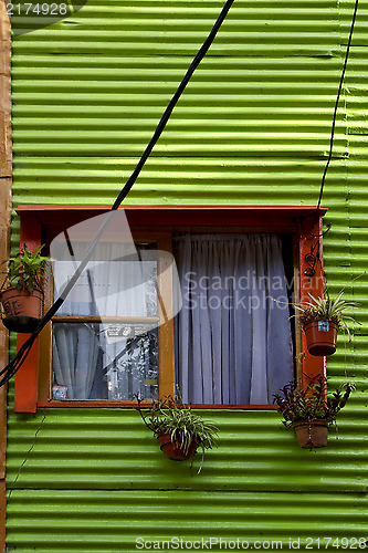 Image of orange wood window and a green metal 