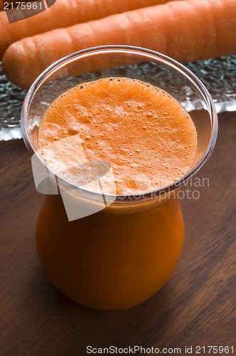 Image of carrot juice on a wooden background 