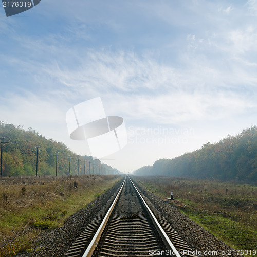 Image of railway goes to horizon in fog