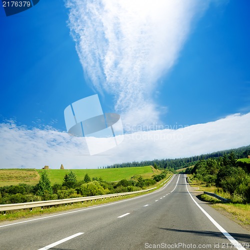 Image of road in mountain under cloudy sky