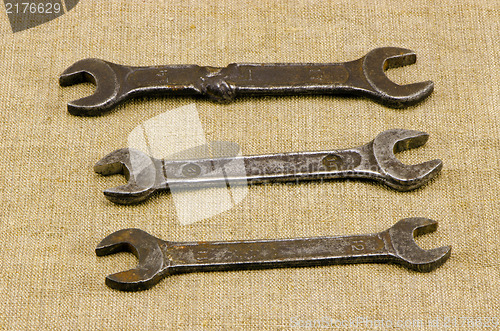 Image of three retro screw spanners wrench tools on linen 