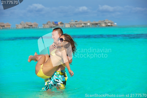 Image of happy young  couple enjoying summer on beach