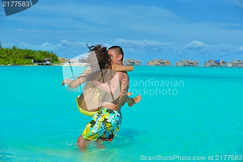 Image of happy young  couple enjoying summer on beach