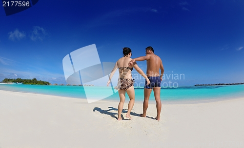 Image of happy young  couple enjoying summer on beach