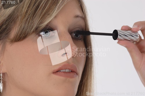 Image of Woman applying eyelash makeup