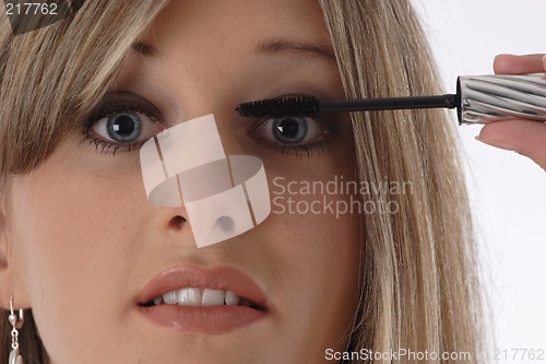 Image of Woman applying eyelash makeup