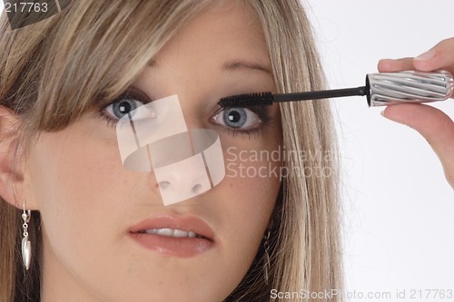 Image of Woman applying eyelash makeup