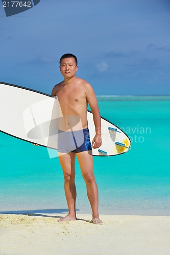 Image of Man with surf board on beach