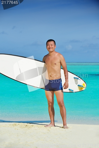Image of Man with surf board on beach