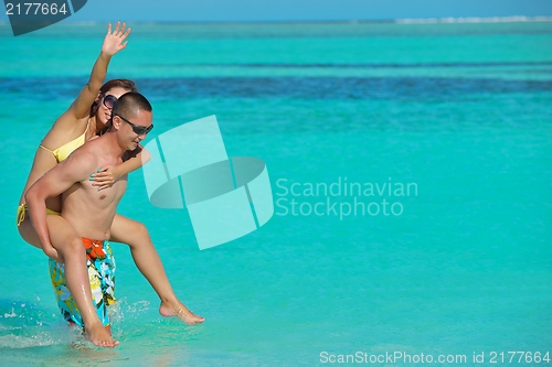 Image of happy young  couple enjoying summer on beach