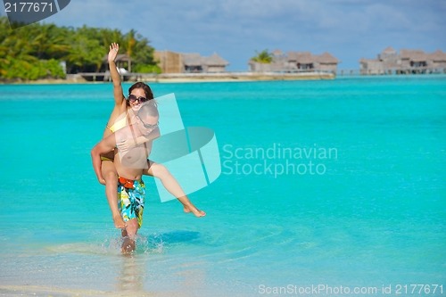 Image of happy young  couple enjoying summer on beach