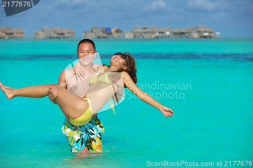 Image of happy young  couple enjoying summer on beach