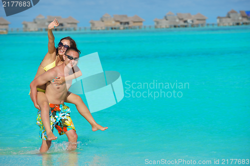 Image of happy young  couple enjoying summer on beach