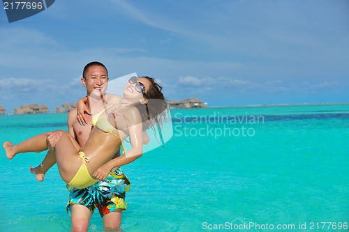 Image of happy young  couple enjoying summer on beach