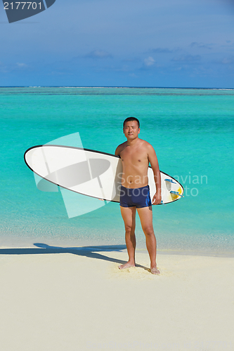Image of Man with surf board on beach