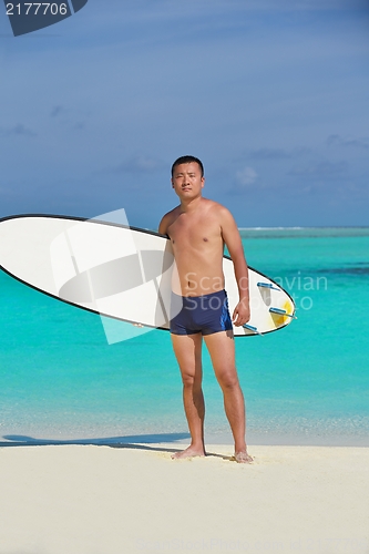 Image of Man with surf board on beach