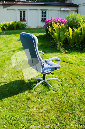 Image of blue office chair in sunny meadow 