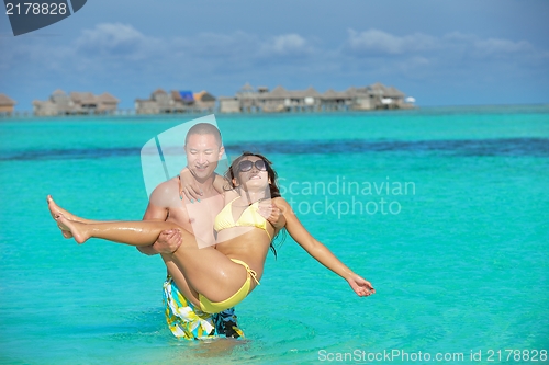 Image of happy young  couple enjoying summer on beach