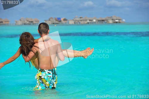 Image of happy young  couple enjoying summer on beach