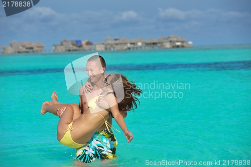 Image of happy young  couple enjoying summer on beach