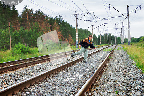Image of Elderly man crosses a railway embankment