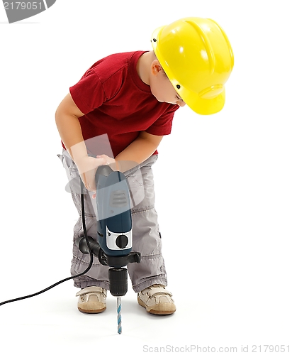 Image of Little boy drilling in ground, wearing protective helmet