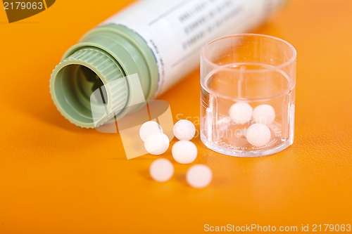 Image of Homeopathic pills, container on orange