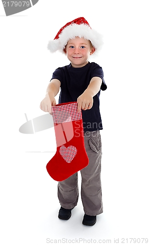 Image of Smiling boy holding christmas stocking in front of him