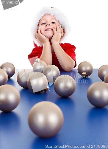 Image of Little boy sitting behind Christmas ornaments