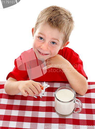 Image of Young kid playing with toy cow near glass of milk