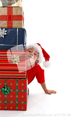 Image of Young boy smiling behind presents