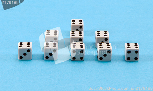 Image of white gamble dice pyramid blue background 