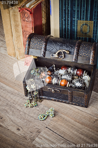 Image of  casket with jewelry and old book on a wooden surface 