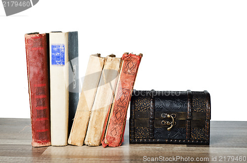 Image of  casket and old book on a wooden surface 