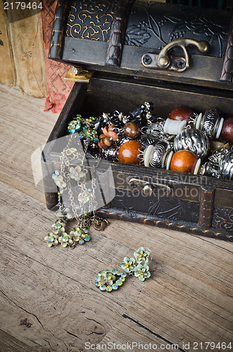 Image of  casket with jewelry and old book on a wooden surface 