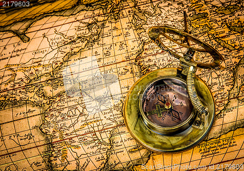 Image of Vintage compass lies on an ancient world map.