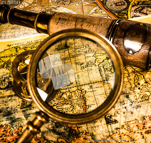 Image of Vintage magnifying glass lies on an ancient world map