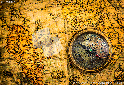 Image of Vintage compass lies on an ancient world map