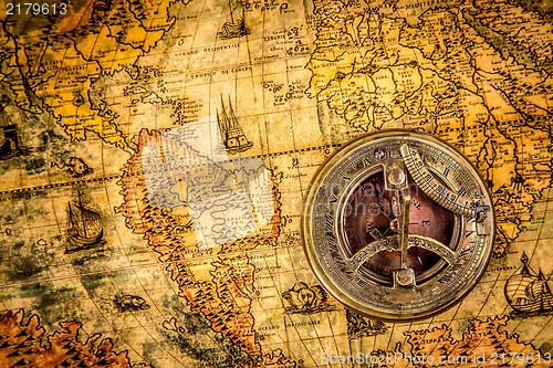 Image of Vintage compass lies on an ancient world map