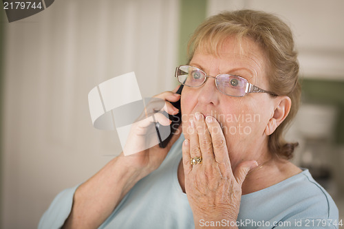 Image of Shocked Senior Adult Woman on Cell Phone in Kitchen