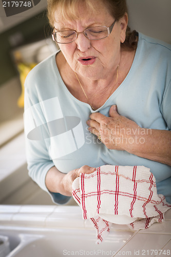 Image of Senior Adult Woman At Sink With Chest Pains